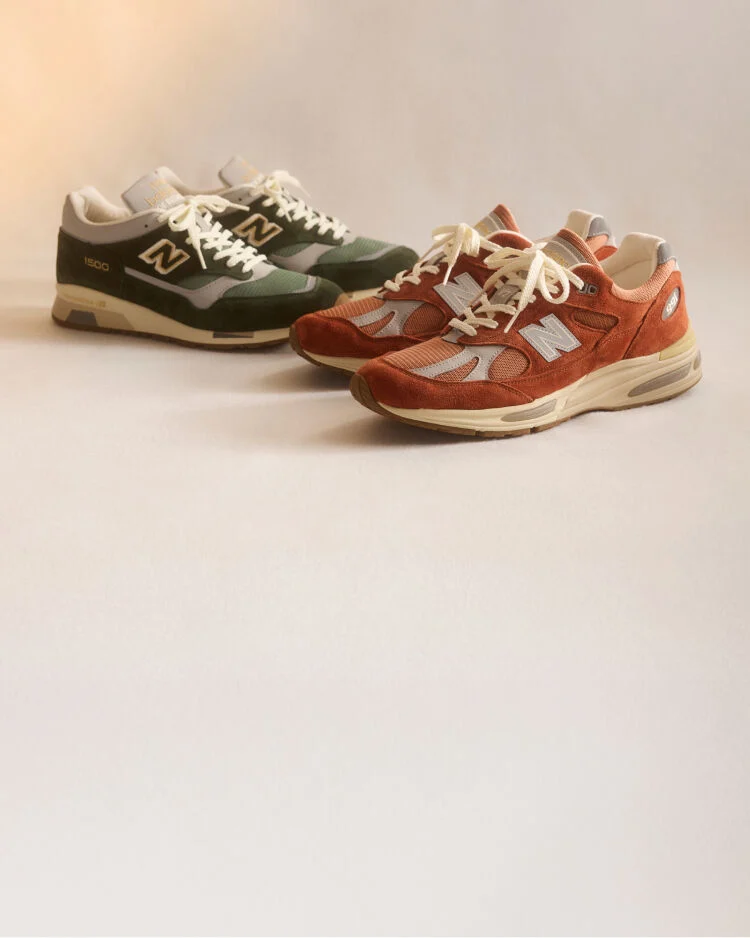 Two pairs of New Balance Made in UK sneakers sitting in a studio.