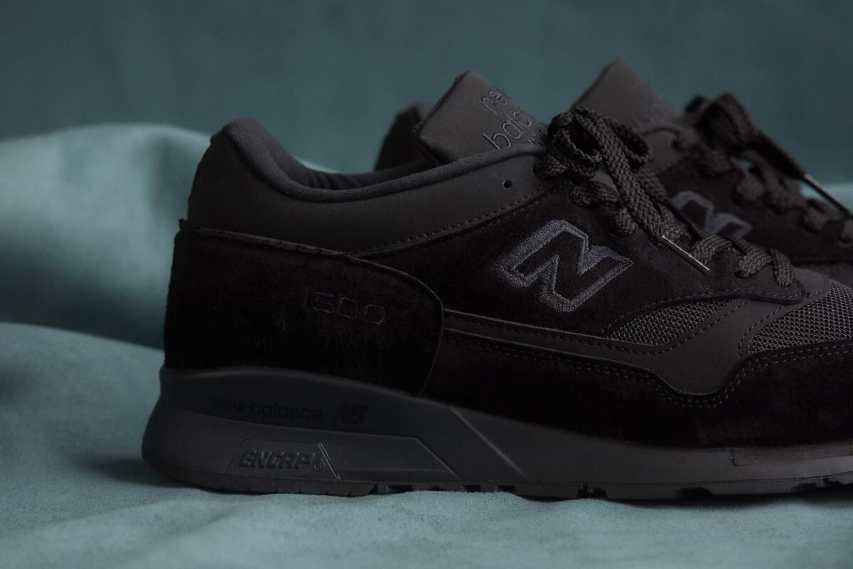 A close up view of the heel of a New Balance Made in UK sneaker on a flowing blue sheet backdrop.