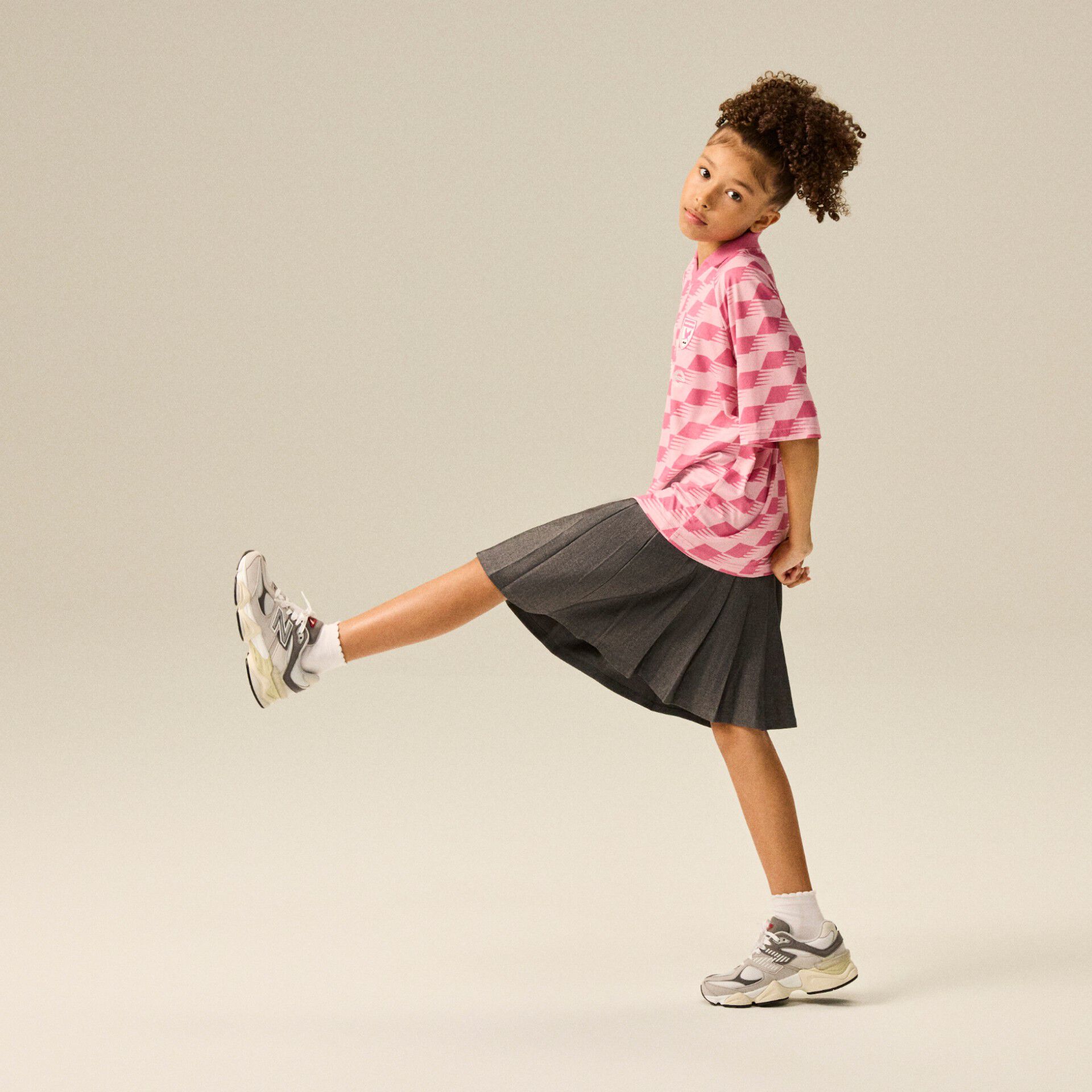 Girl wearing a pair of 9060s kicking her leg up 